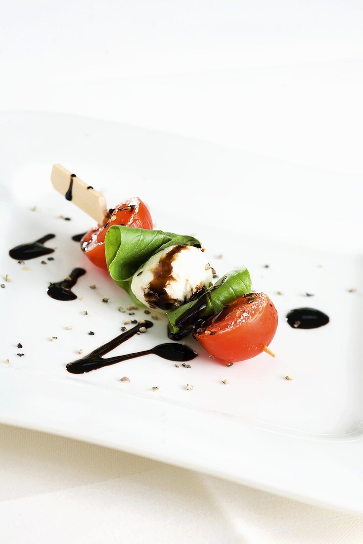 Tomato and mozzarella on a stick with balsamic vinegar