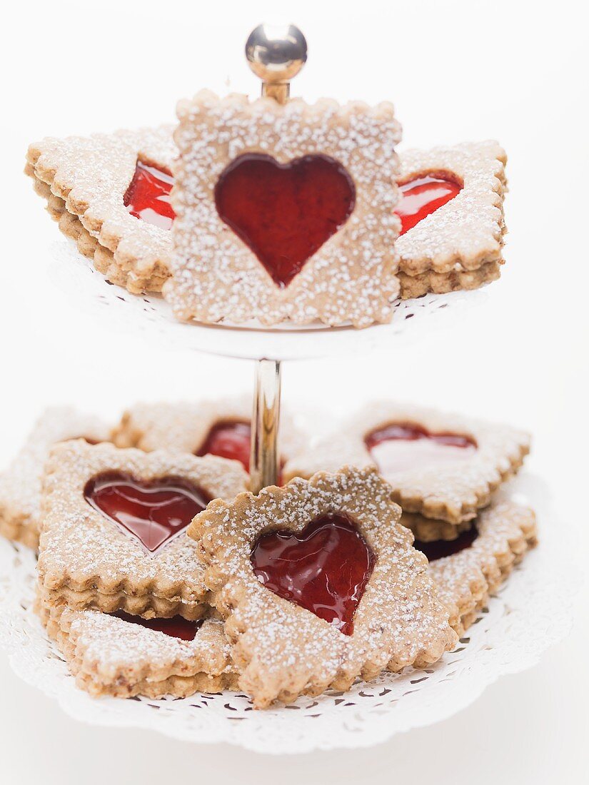 Jam biscuits with icing sugar on a cake stand