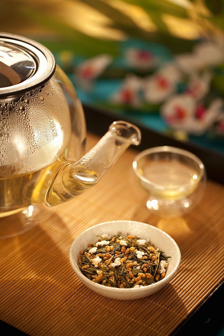 Japanese Genmaicha Tea in a Bowl with Clear Glass Tea Pot and Cup; On Bamboo Tray