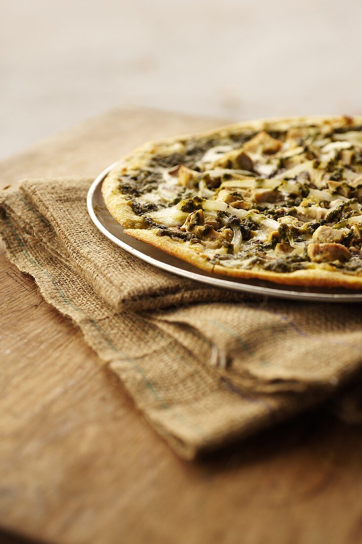 Thin Crust Pizza Topped with Chicken, Mushrooms, Onions and Pesto