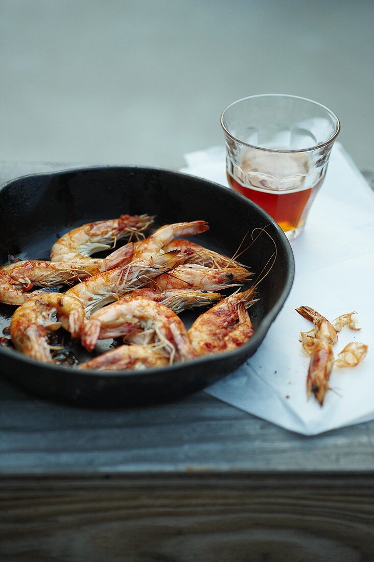 Pan Fried Shrimp in Skillet; Peels and a Glass of Beer