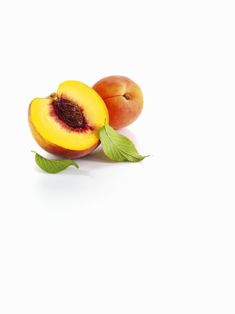 Half a peach and apricots with leaves