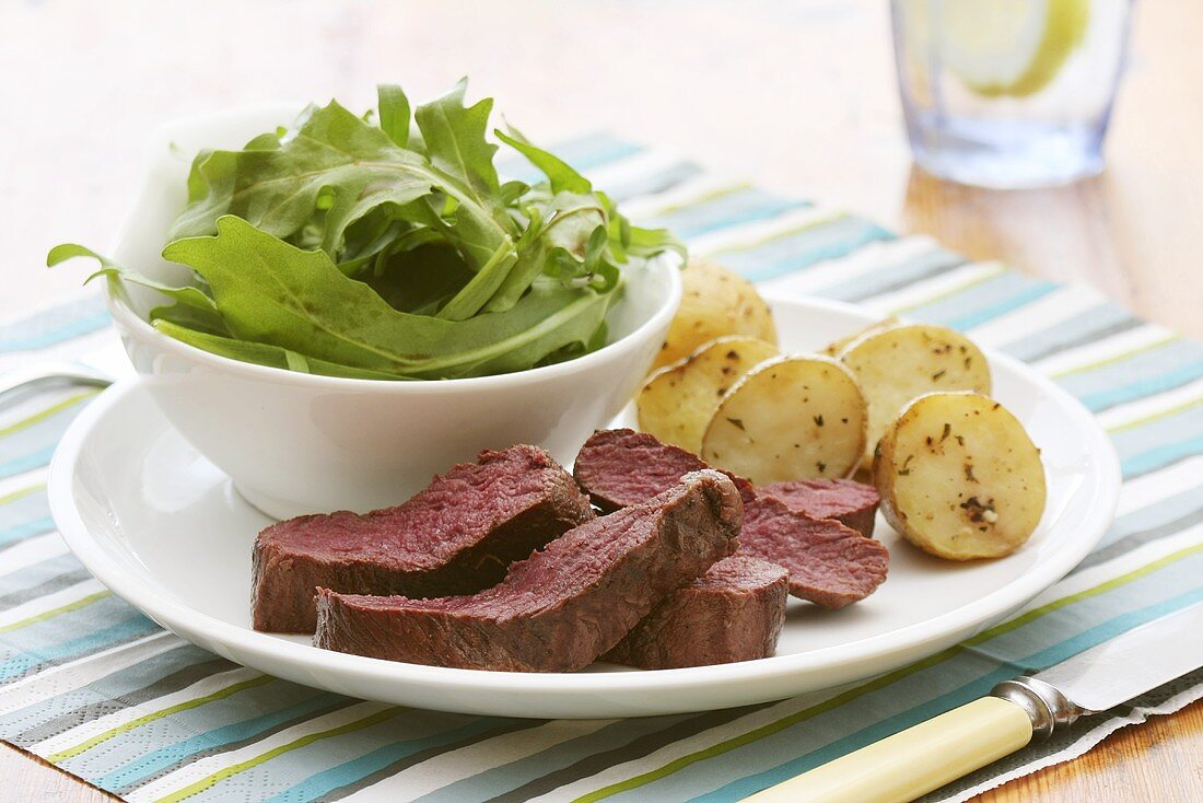 Gebratenes Straussenfilet mit Rucolasalat und Rosmarinkartoffeln