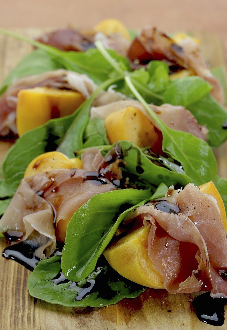 Peaches wrapped in prociutto with rocket and balsamic vinegar