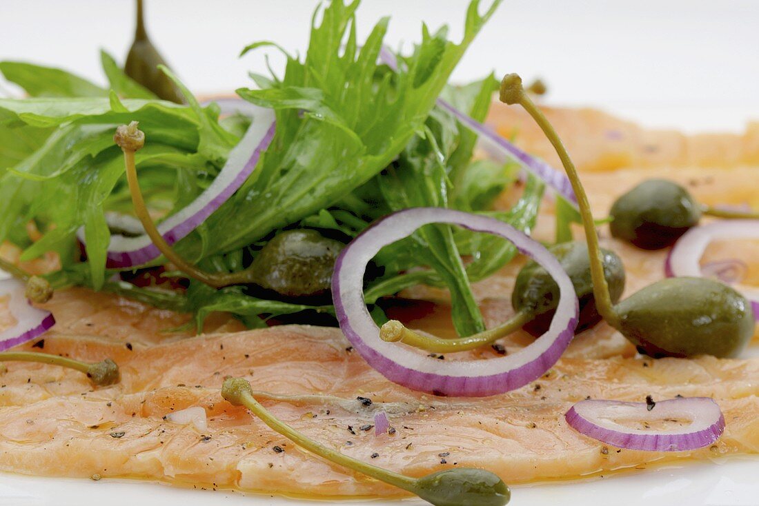 Salmon carpaccio with rocket, onions and capers