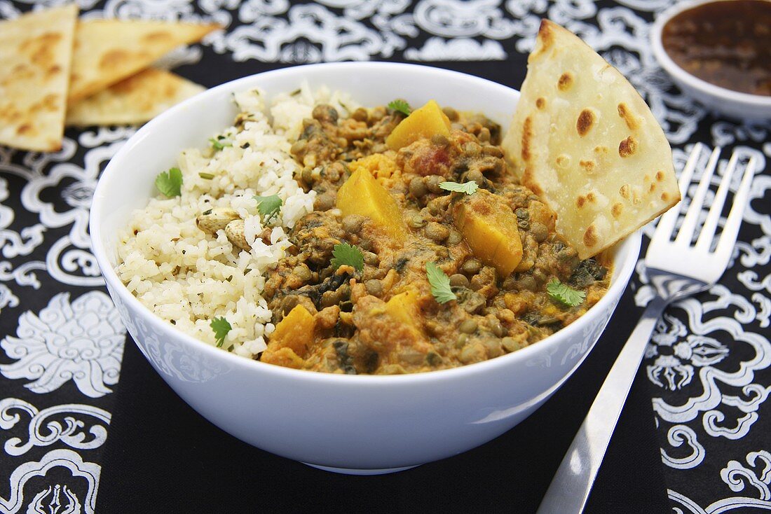 Pumpkin curry with lentils, beans and naan bread (India)
