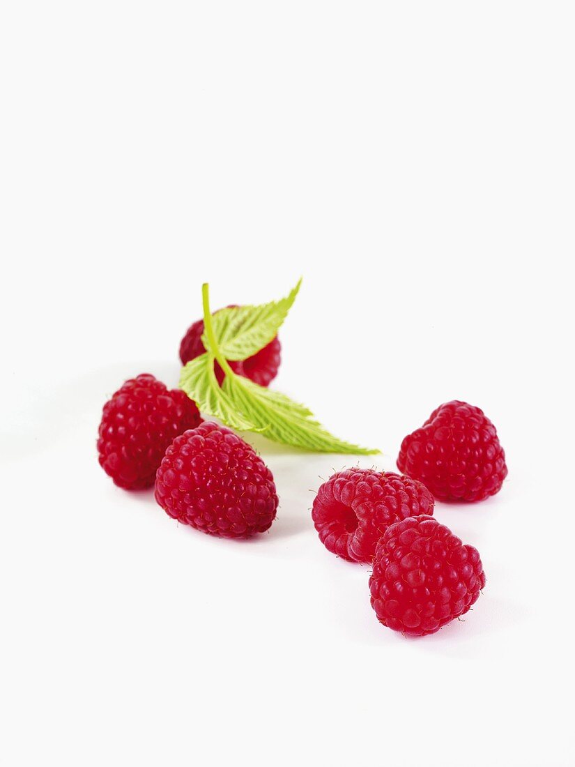 Sechs Himbeeren mit Blättern