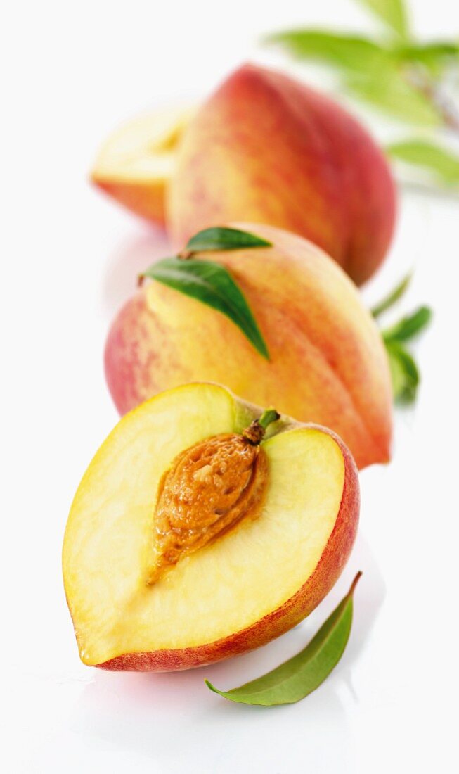 Three white peaches, whole and halved
