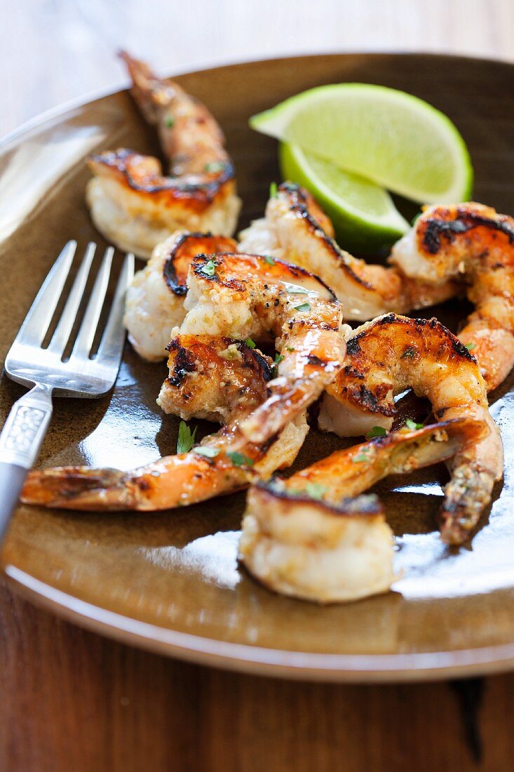 Grilled Spicy Shrimp on a Plate with Lime Wedges