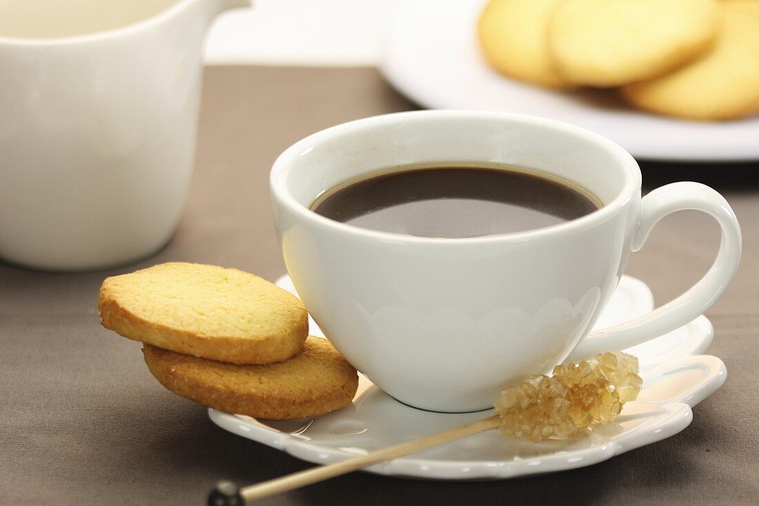 Eine tasse Espersso mit Kandisstange und Butterplätzchen