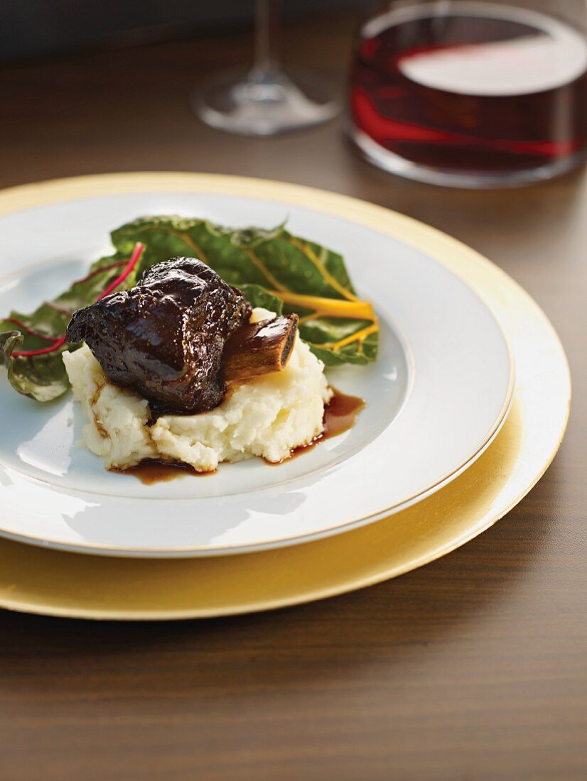 Braised beef ribs on mashed potatoes with chard and red wine