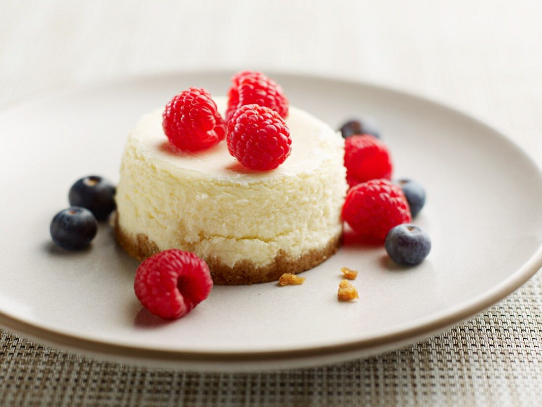 A mini cheesecake with raspberries and blueberries