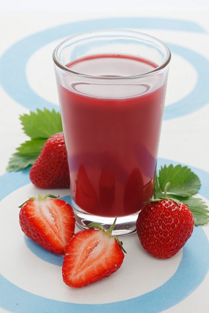 Ein Glas Erdbeersmoothie und frische Erdbeeren