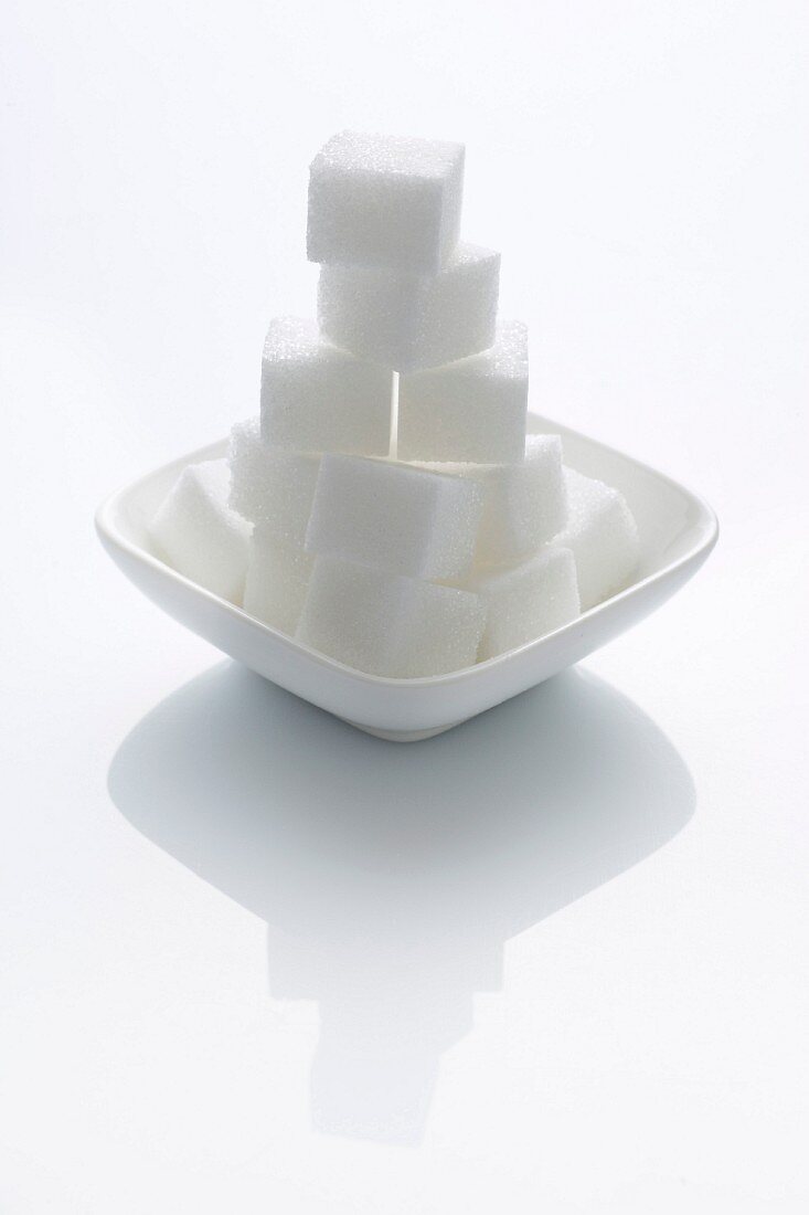 A stack of sugar cubes in a bowl