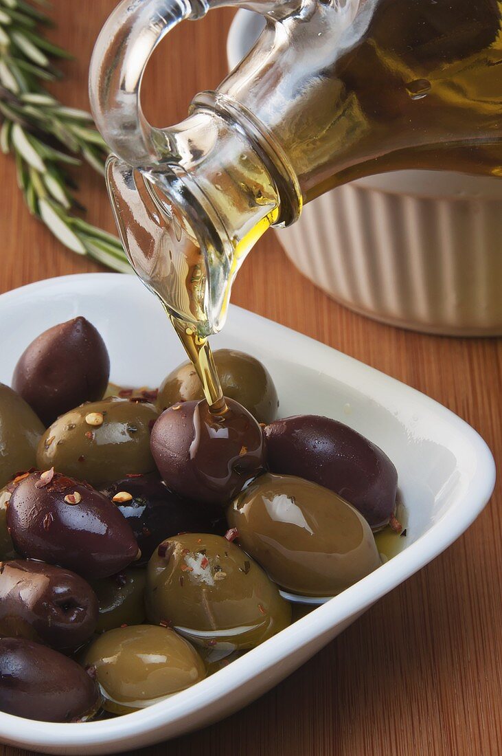 Olivenöl fließt auf Oliven