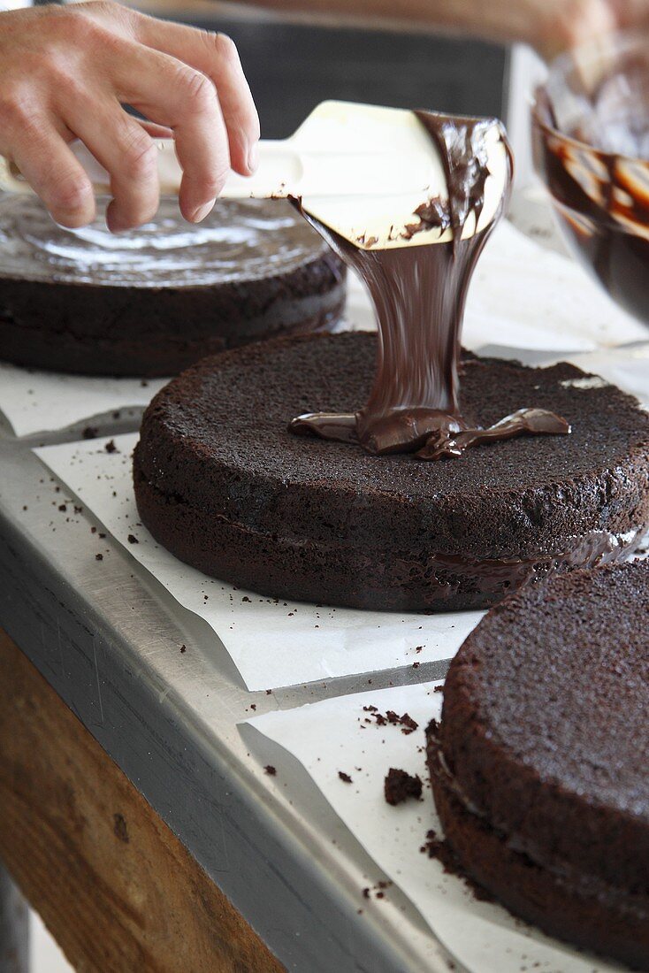A chocolate cake being glazed