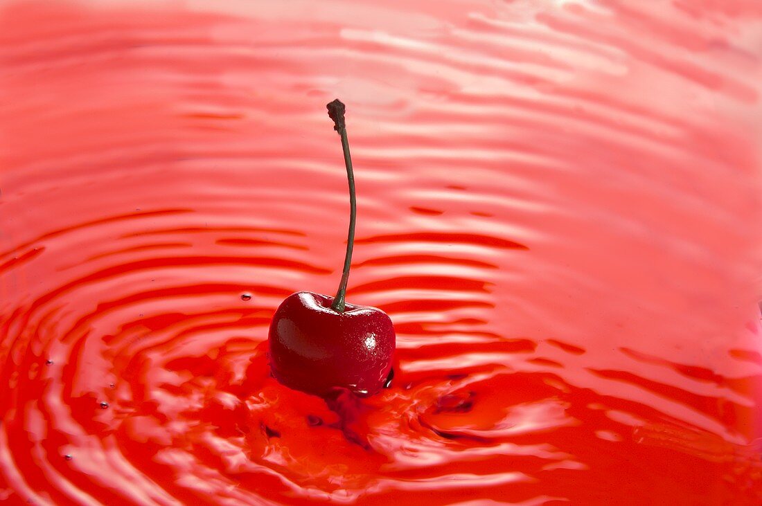 A red cherry in cherry juice