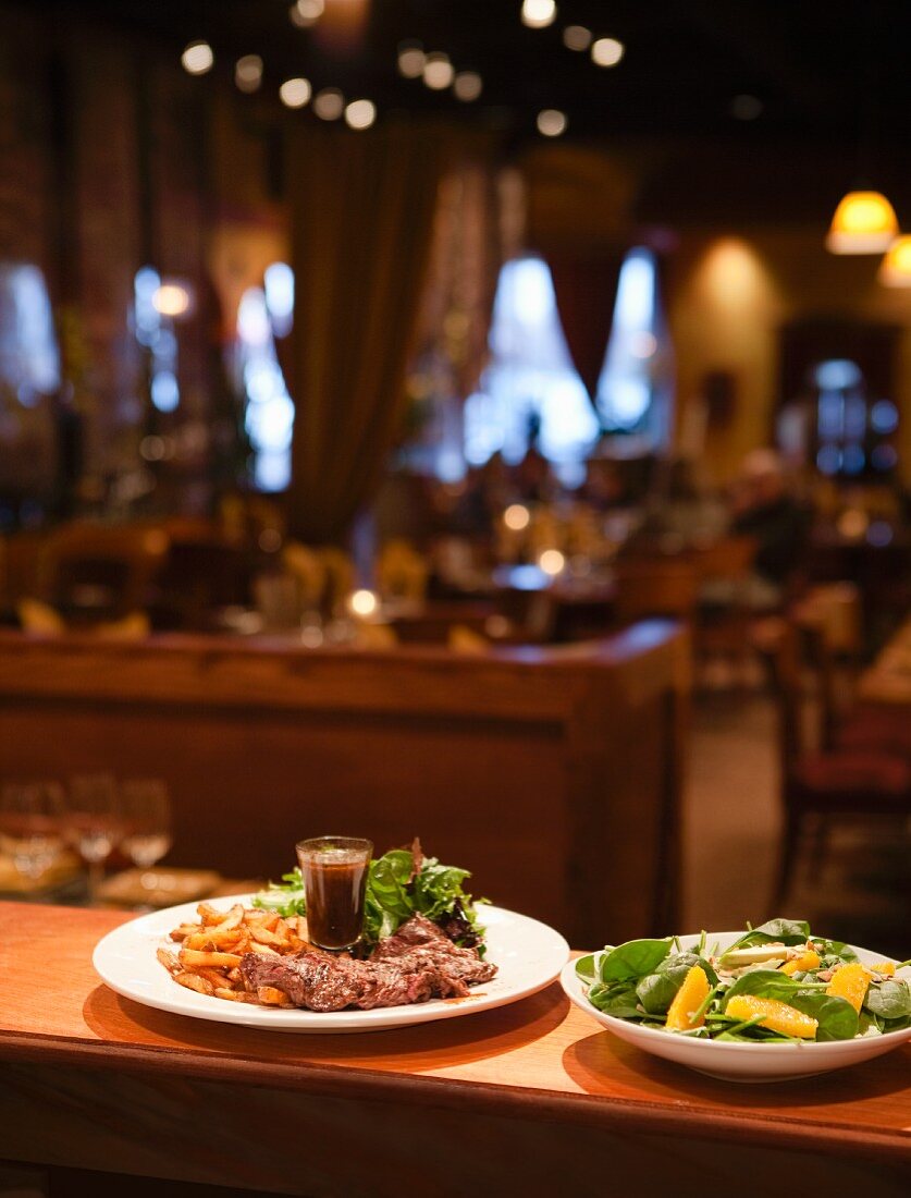 Teller mit Steak und Salat auf Theke eines Restaurants, fertig zum Servieren