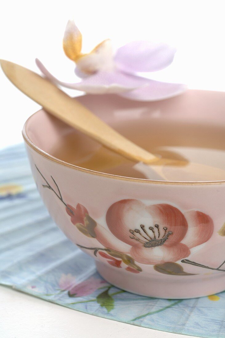 Tea in Asian teacup with wooden spoon