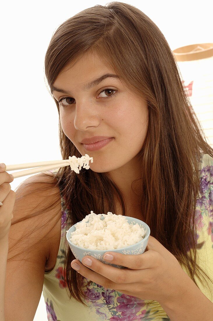 Woman eating rice with chopsticks