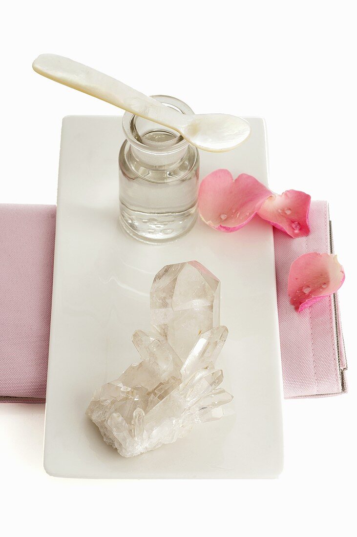 Bergkristall, Apothekerflasche und Blütenblätter