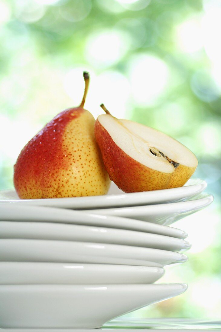 Forelle pears, whole and halved, on stacked plates