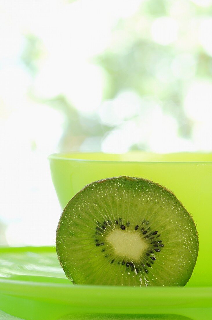 Kiwi fruit in front of green bowl