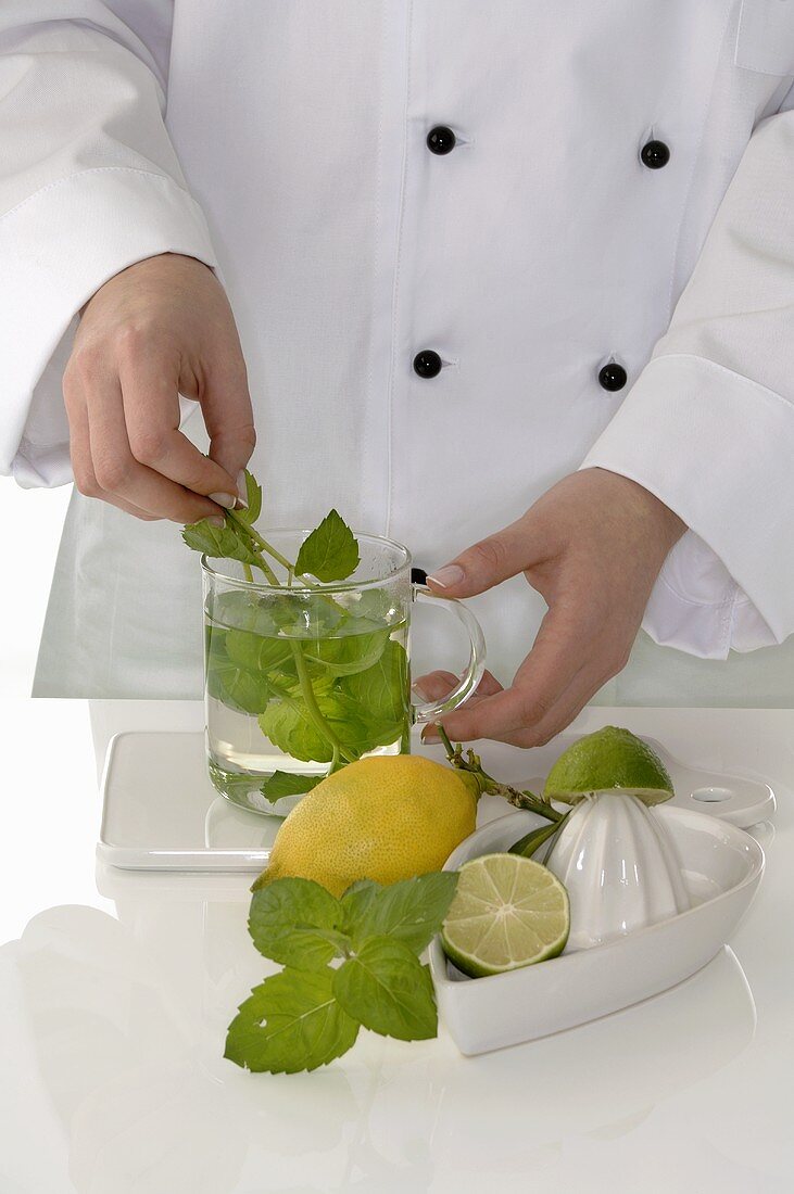Female chef making peppermint tea with lemon