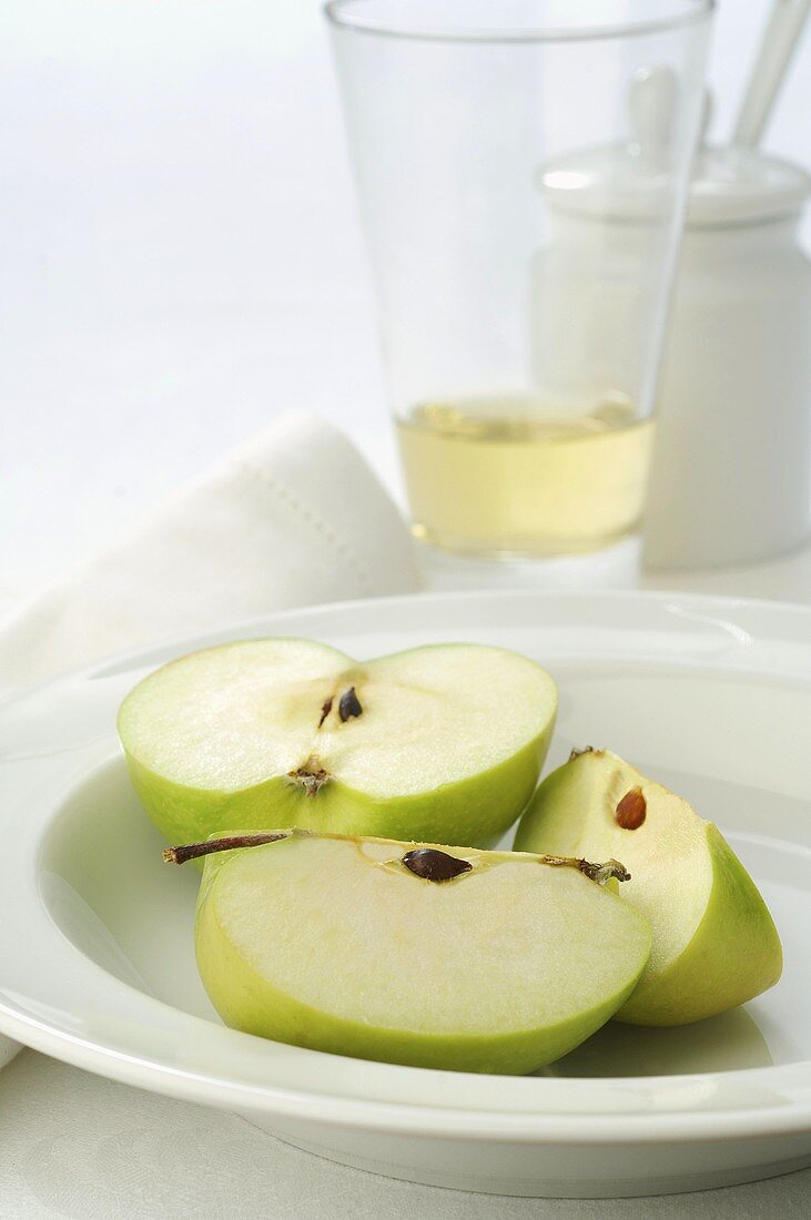 Green apple, cut into pieces, on plate