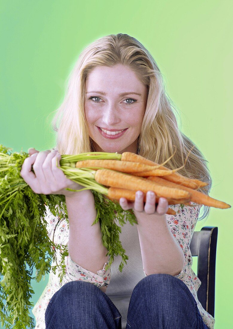 Woman holding fresh carrots