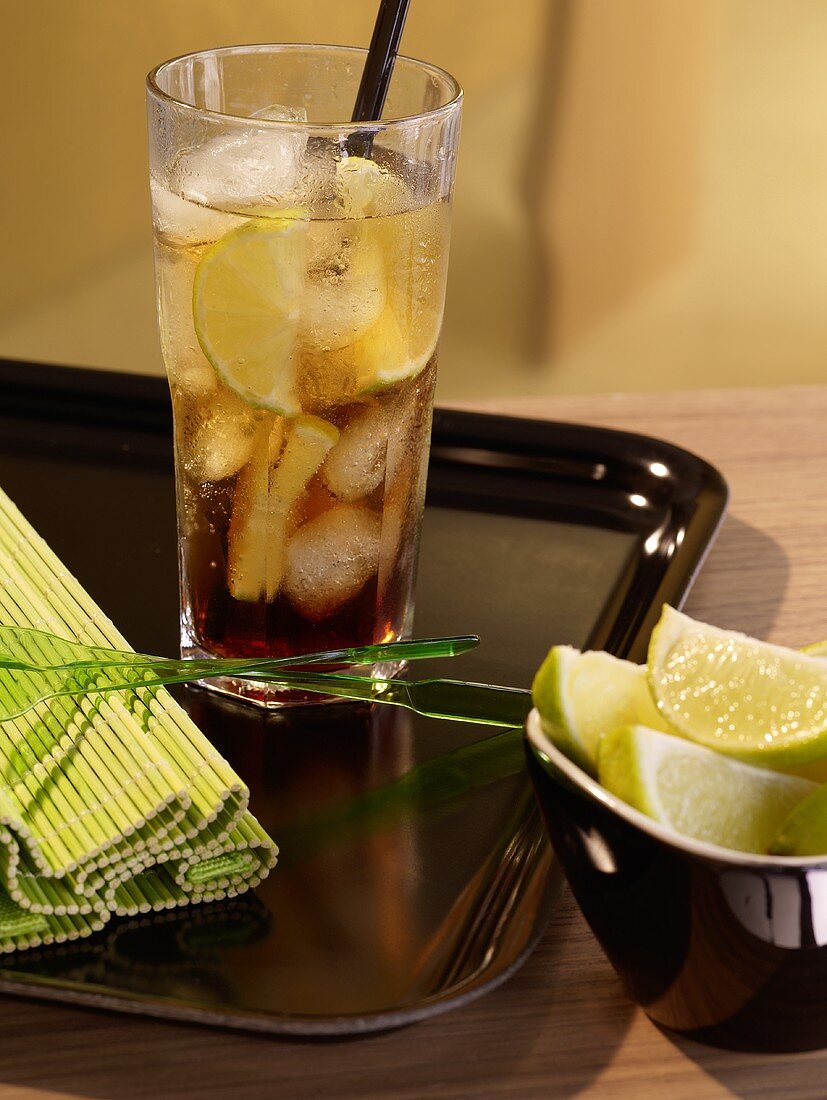 Drink with lime and ice cubes on tray