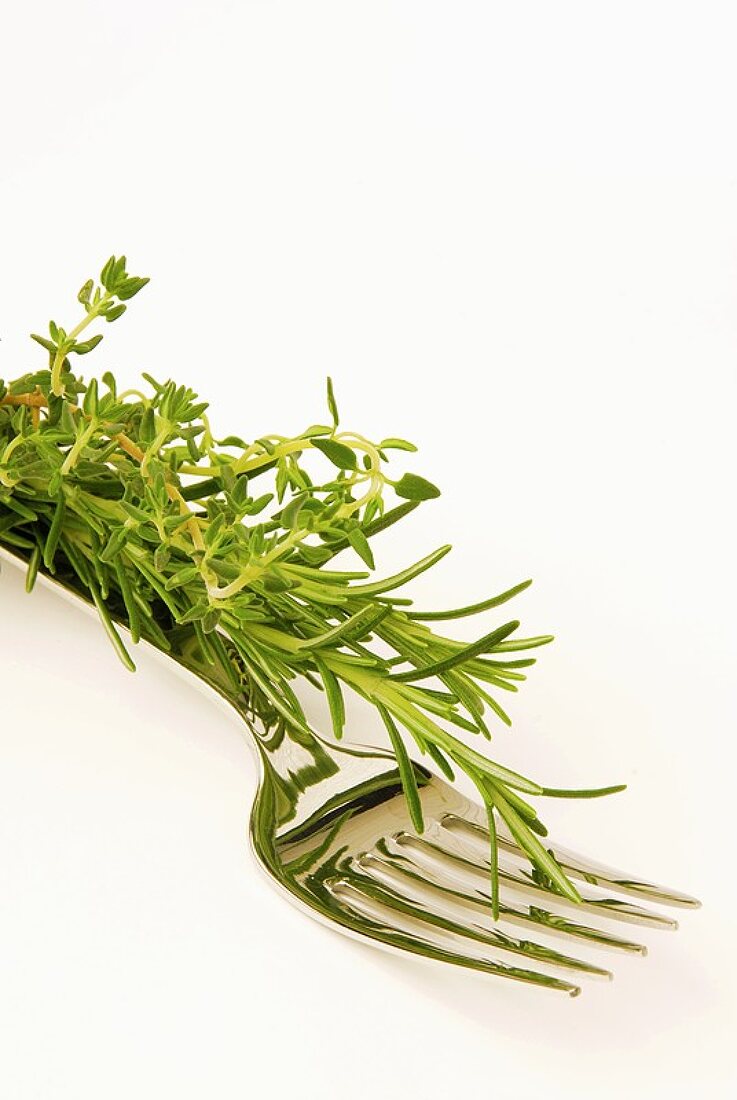 Sprigs of rosemary and thyme on a fork