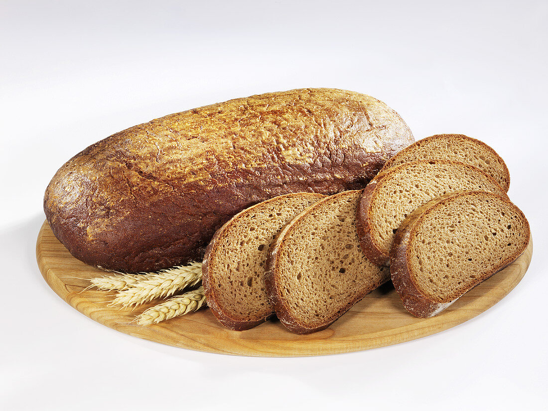 Ganzer Schwarzbrotlaib mit Brotscheiben