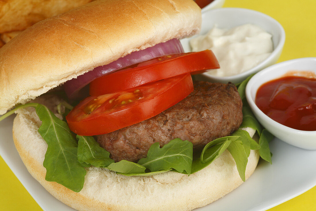 Hamburger with tomato, rocket, mayonnaise and ketchup