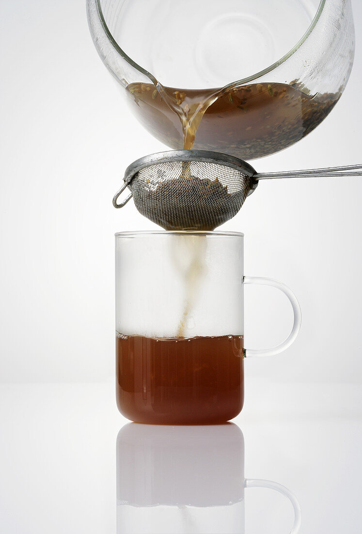 Straining herb tea through a strainer