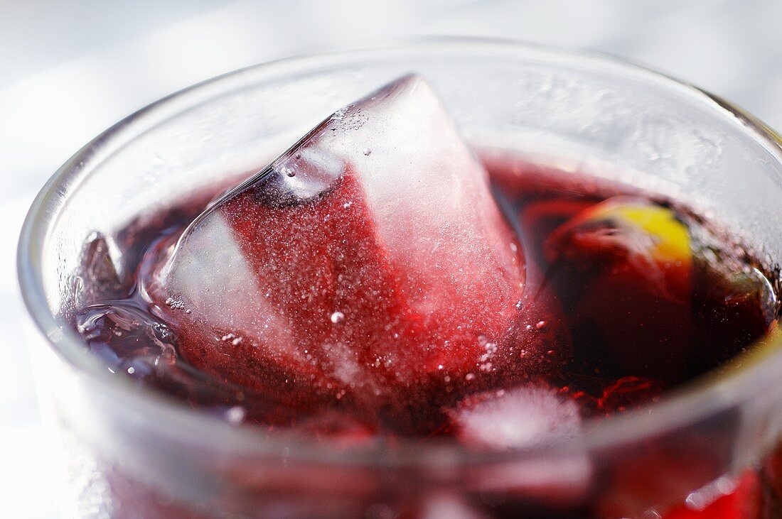 Roter Fruchtsaft mit Eiswürfeln in einem Glas