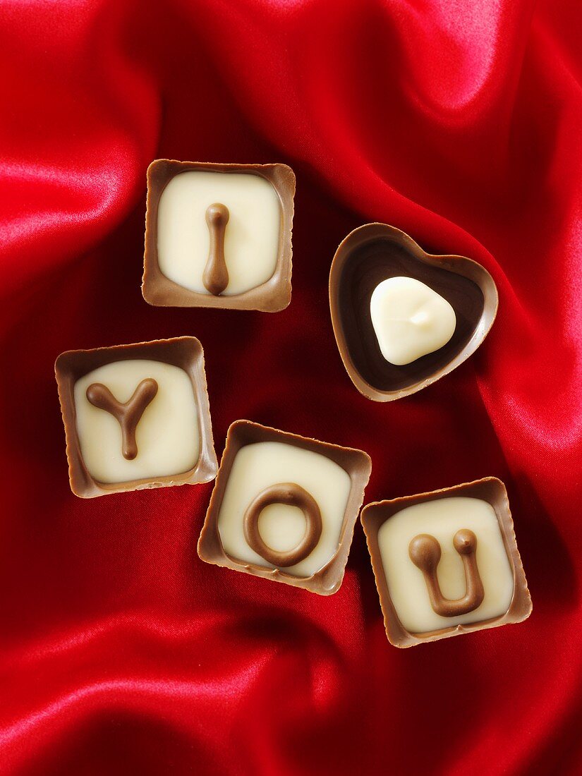 Chocolates on red fabric with the message 'I love you'