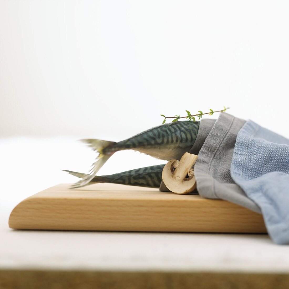 Two mackerel in a fabric napkin with mushroom and thyme