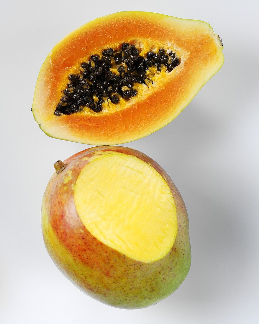 Mango with a slice removed and half a papaya