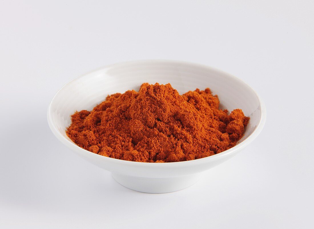 Rotes Currypulver in einem Porzellanschälchen