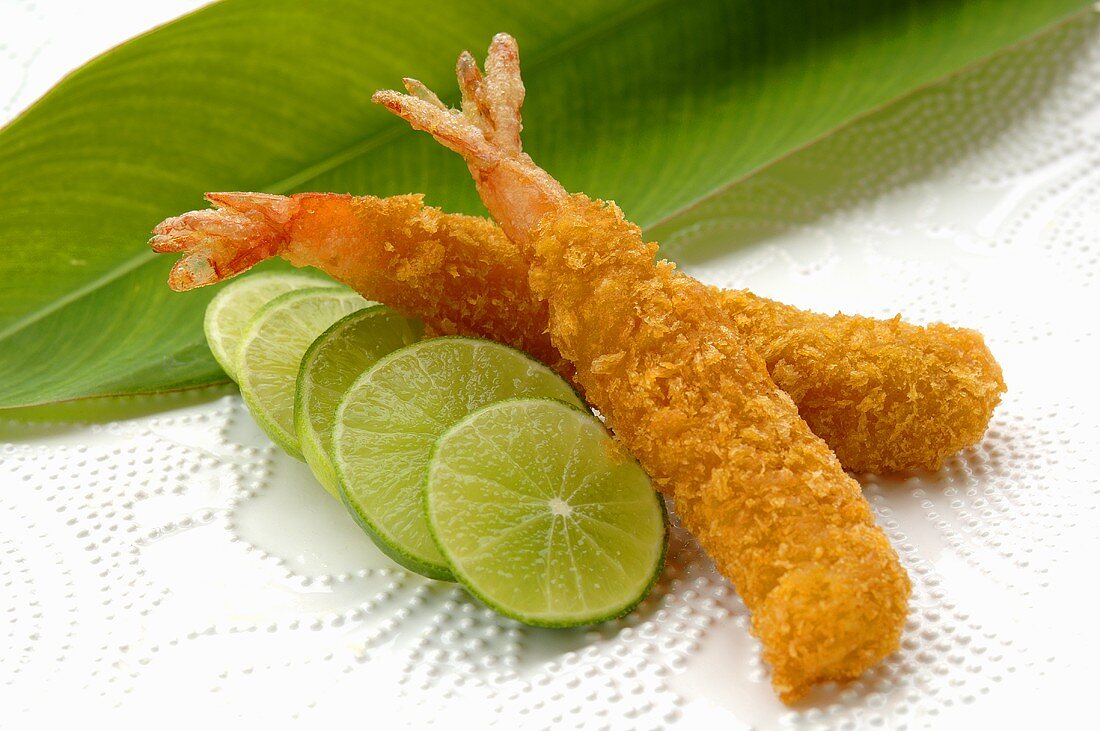 Breaded, deep-fried prawns with slices of lime