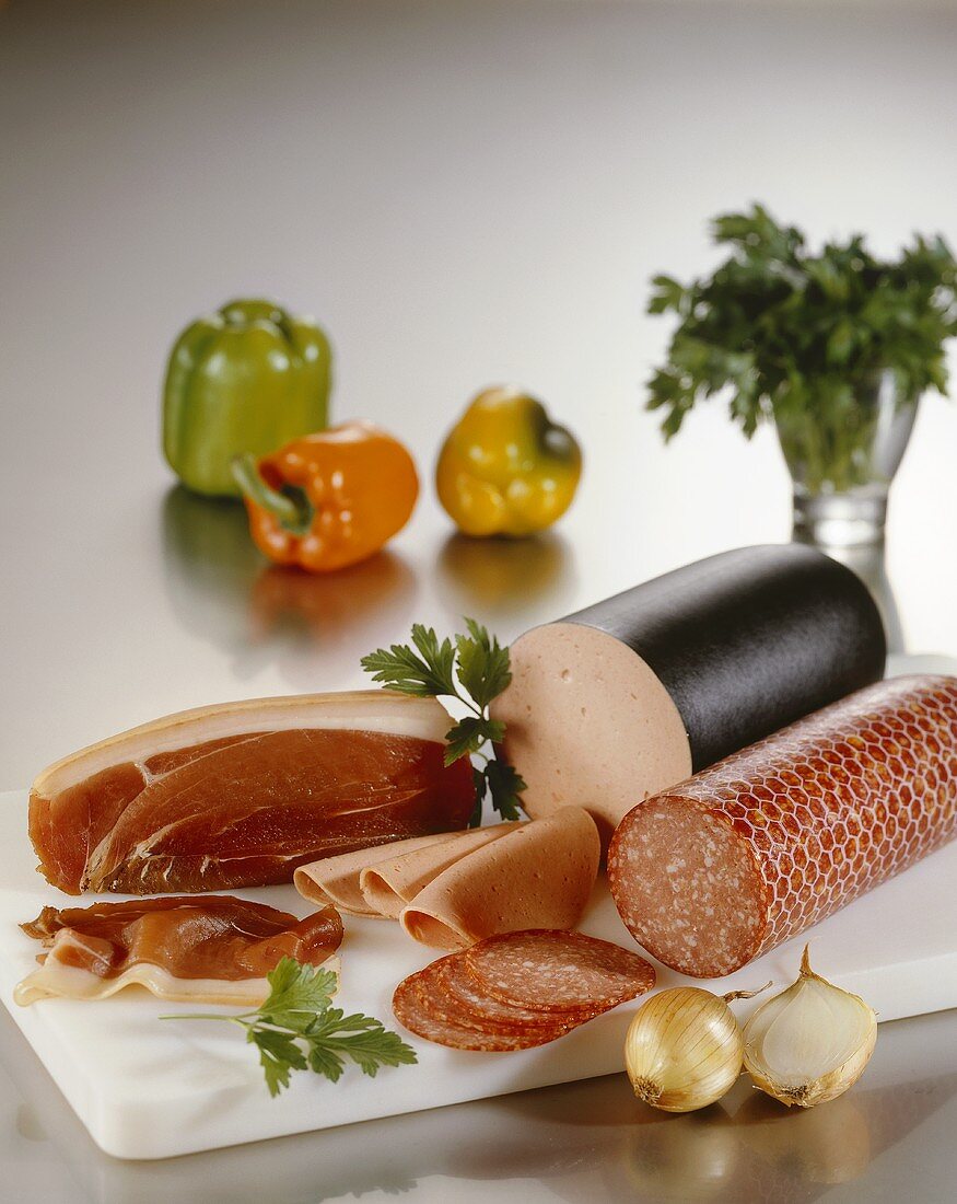 Smoked ham, bologna sausage and salami on chopping board