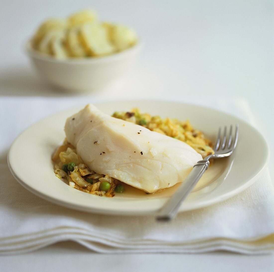 Poached cod on vegetables with potatoes