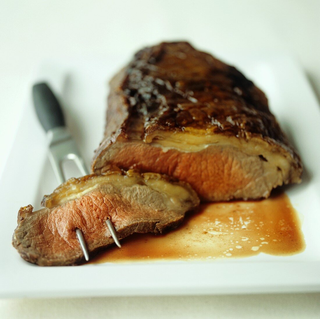 Roast beef with a slice on meat fork