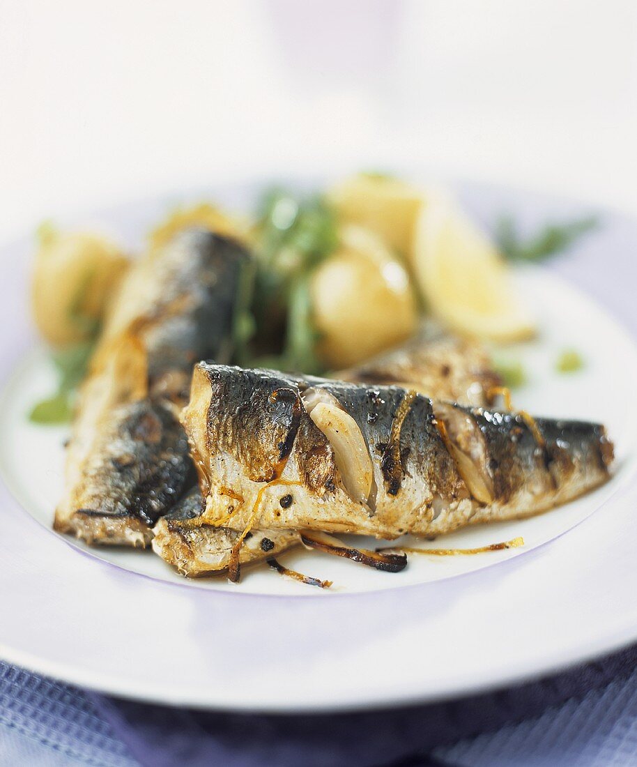 Fried sardines with onions, potatoes and rocket