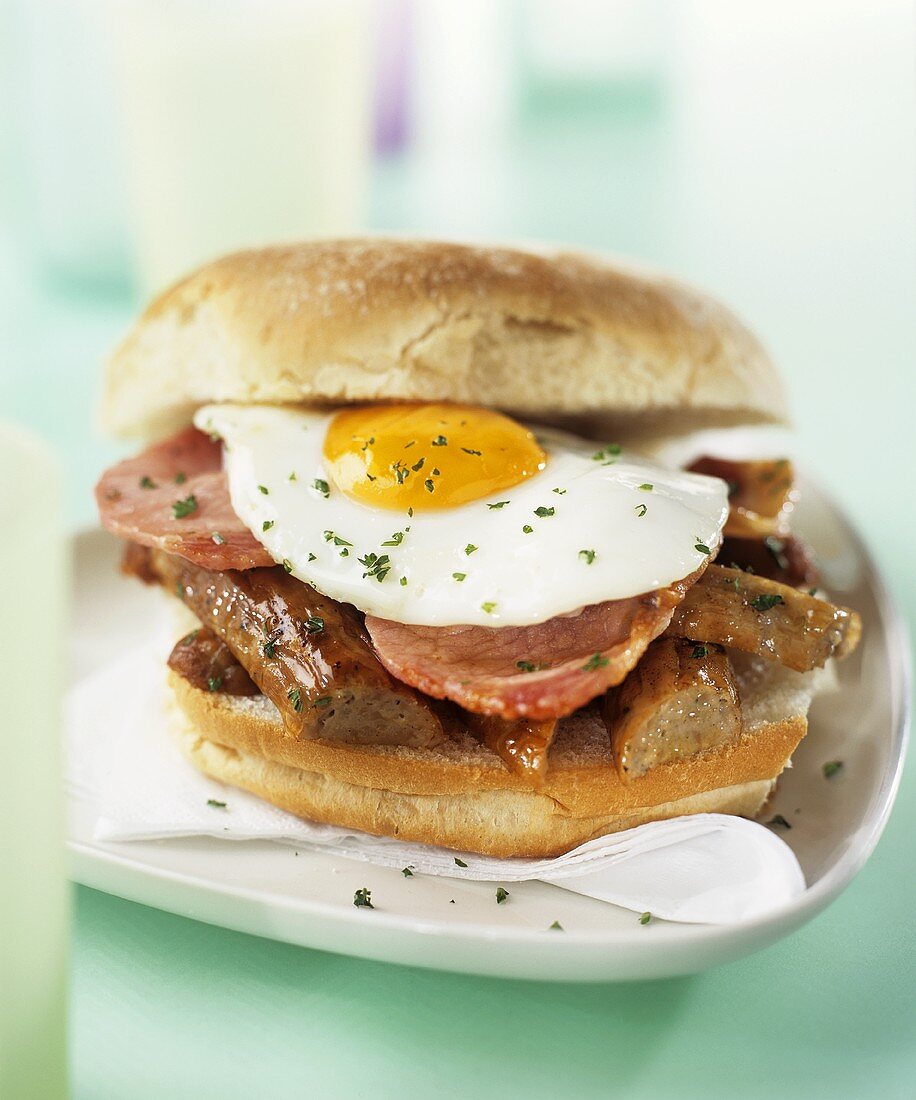 Sandwich mit gebratenen Würstchen, Schinken und Spiegelei