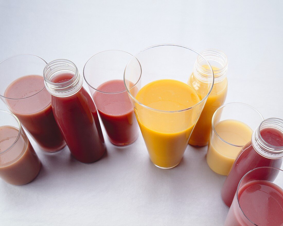Various smoothies in plastic bottles and glasses