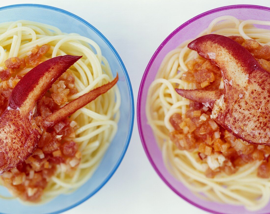 Zwei Teller Spaghetti mit Tomatensauce und Hummer