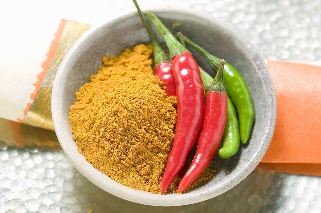Curry powder and chili peppers in bowl