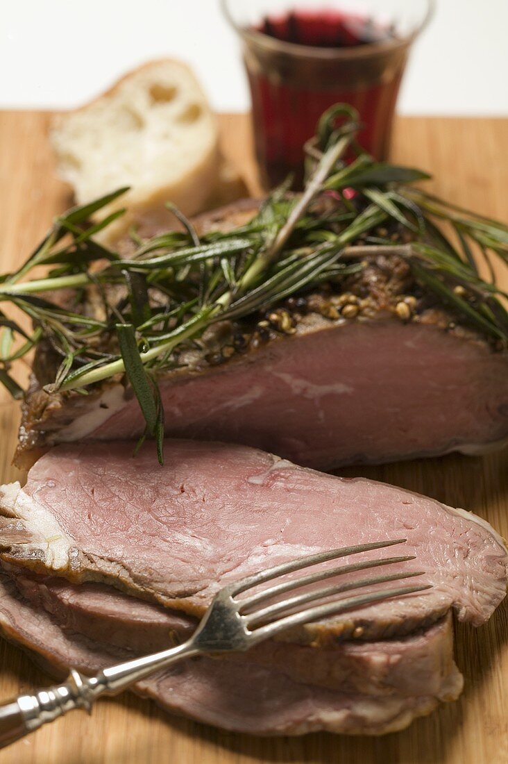 Roast lamb with rosemary, slices carved, white bread, red wine
